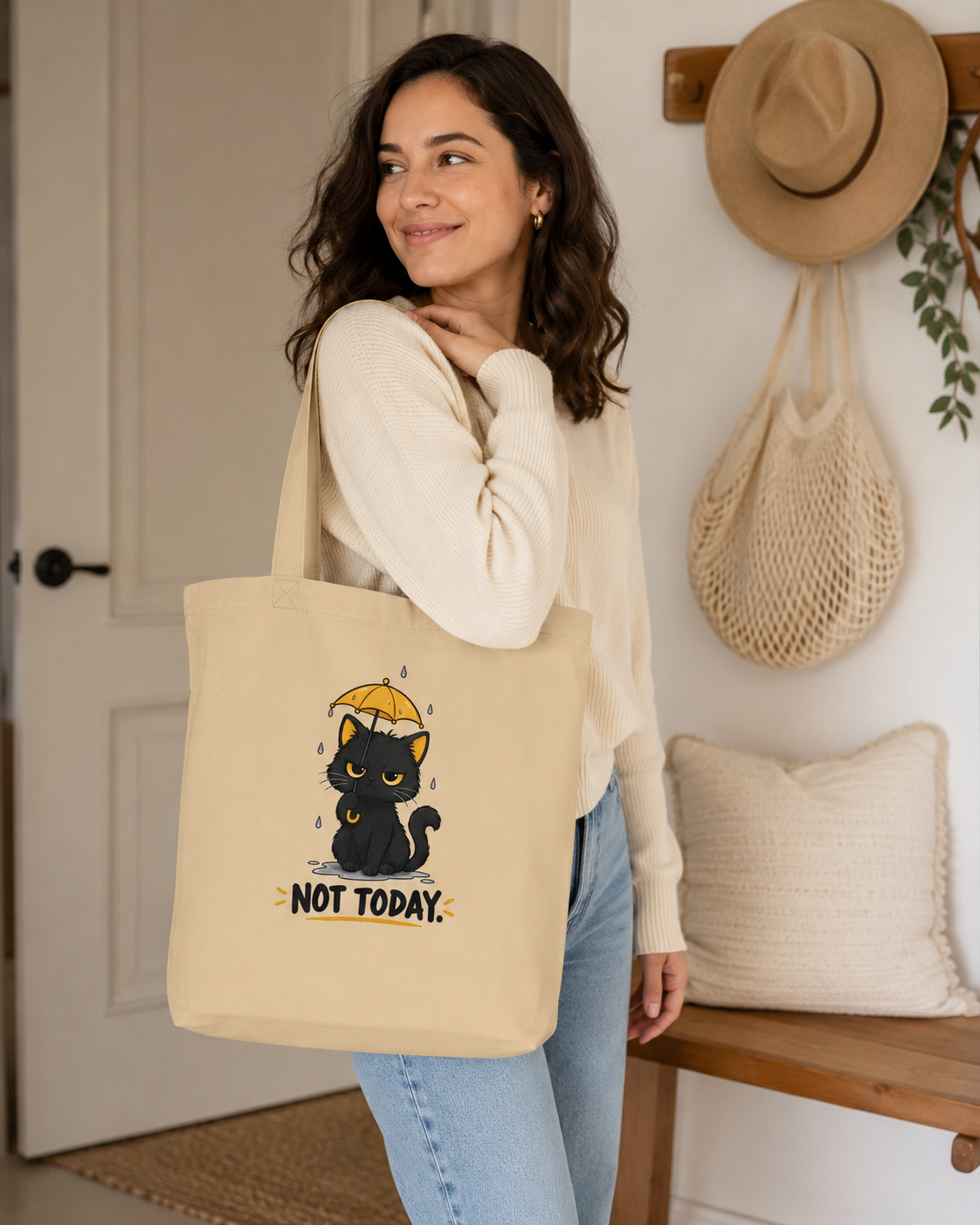 Woman carrying Oyster black cat tote bag with yellow umbrella and Not Today front design
