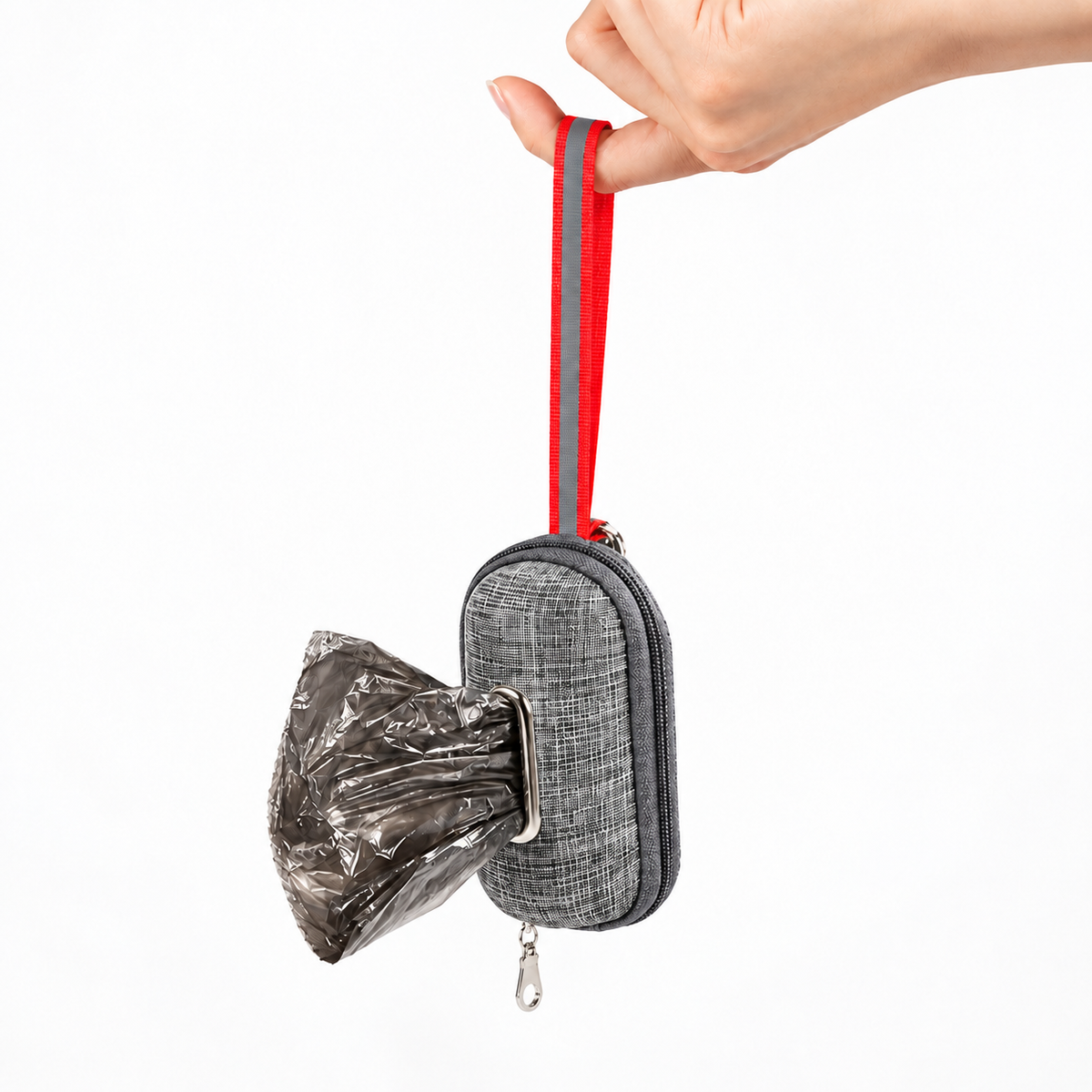 Dark Grey dog poop bag dispenser pouch hanging by its red loop with a waste bag pulled through the opening