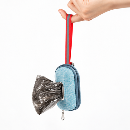 Lake Blue dog poop bag dispenser pouch hanging by its red loop with a waste bag pulled through the opening