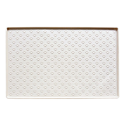 Cream paw texture pet feeding mat with raised edge on a white background