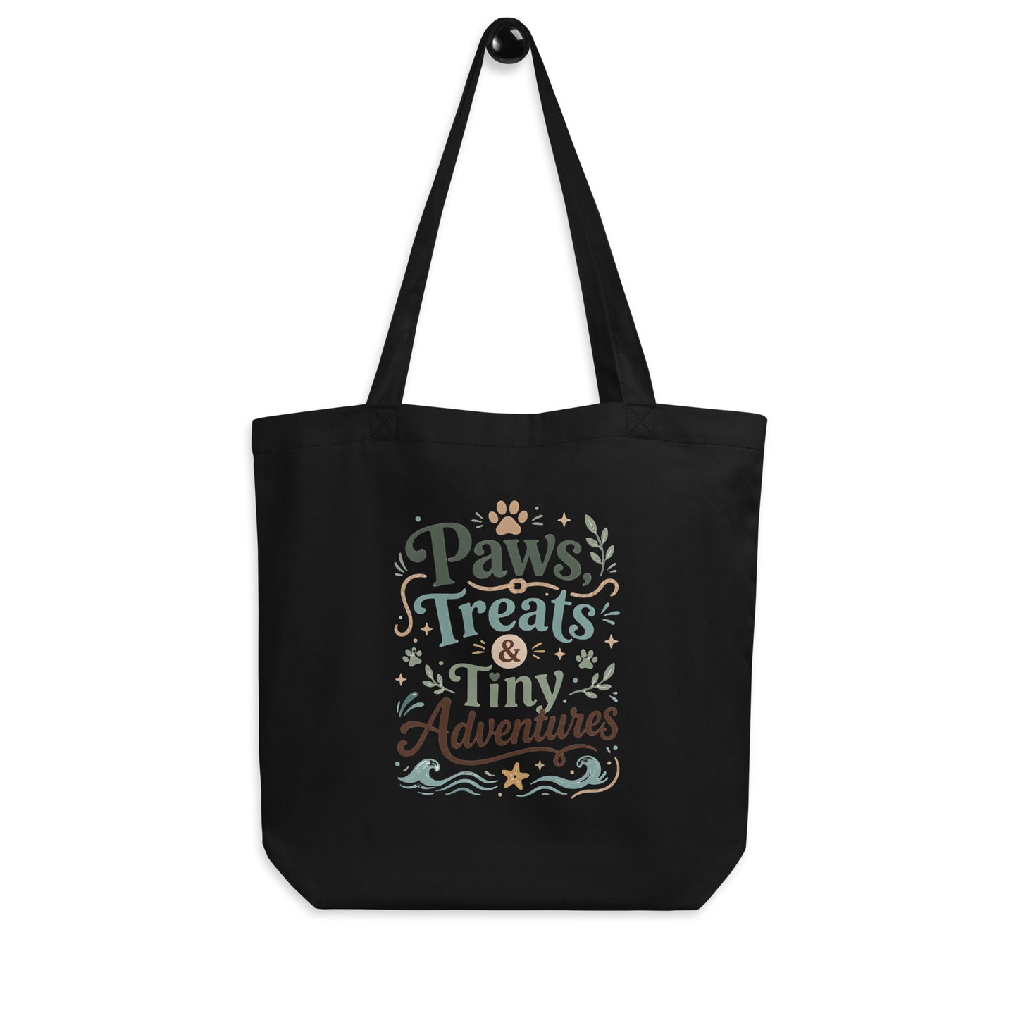 Angled view of the black Paws, Treats & Tiny Adventures organic cotton tote bag.