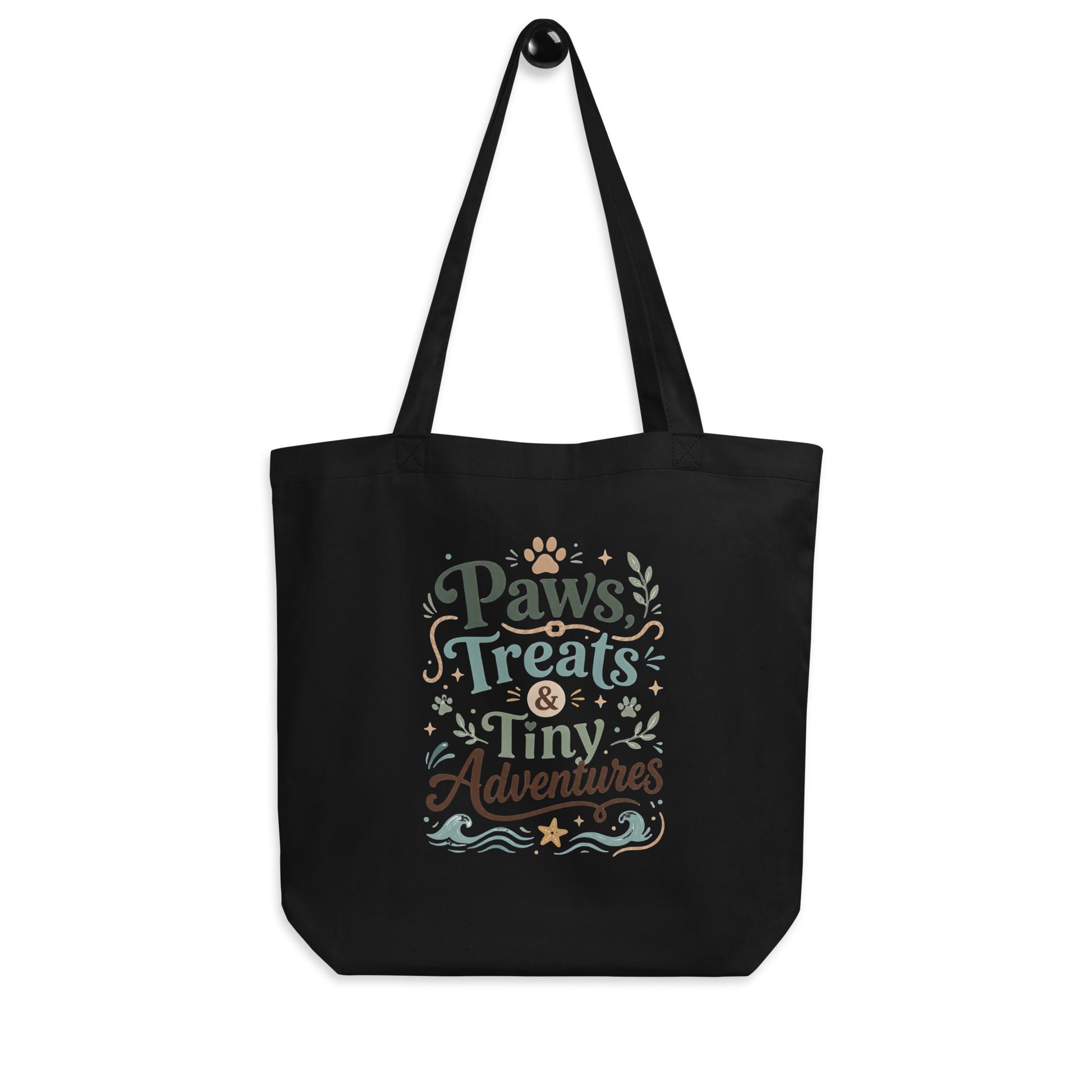 Angled view of the black Paws, Treats & Tiny Adventures organic cotton tote bag.