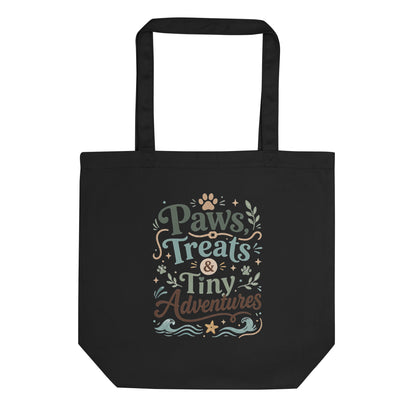 Black organic cotton tote bag with Paws, Treats & Tiny Adventures pet parent artwork.
