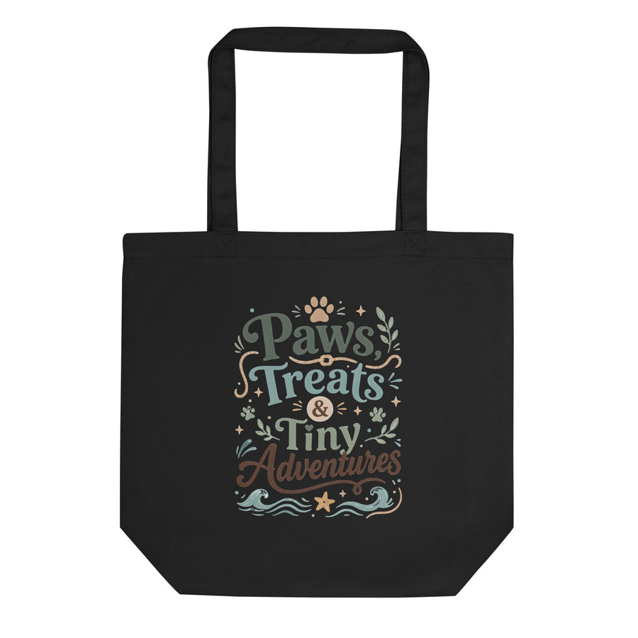 Black organic cotton tote bag with Paws, Treats & Tiny Adventures pet parent artwork.