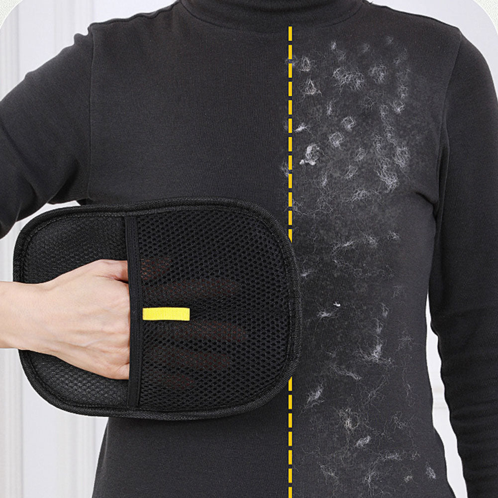 Hand using a black pet grooming mitt to collect loose pet hair from fabric.